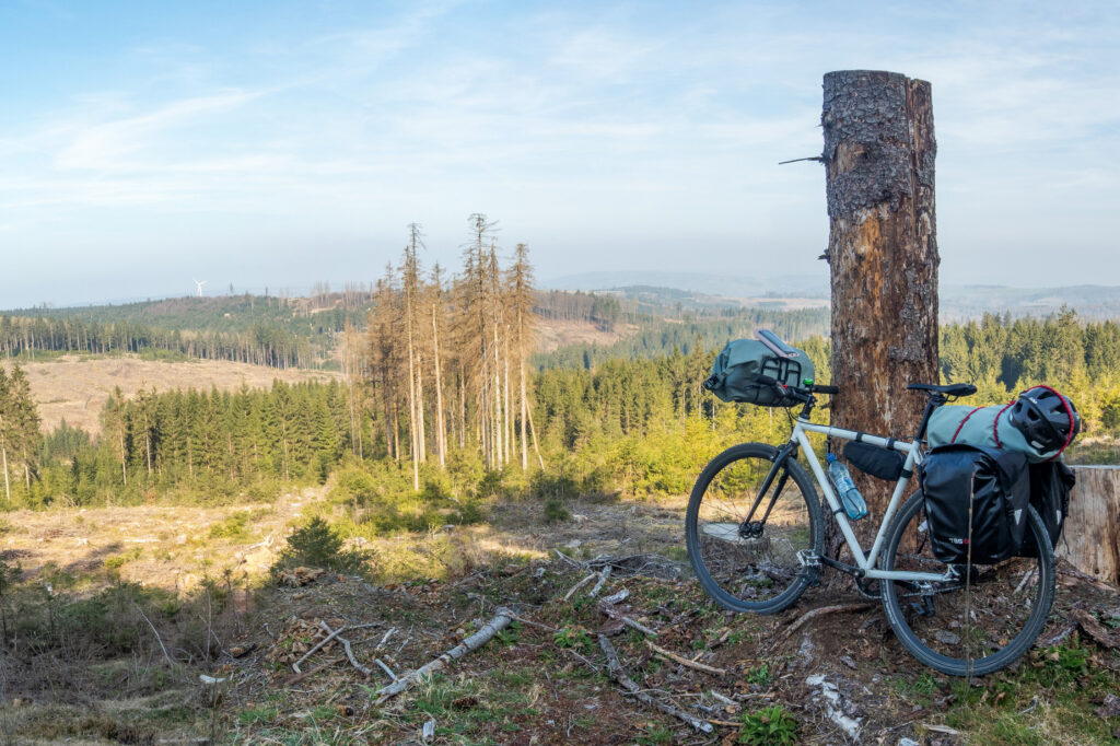 Rad mit Gepäck vor entwaldeter Landschaft im Harz. Radtour Grünes Band.