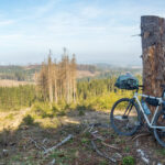 Rad mit Gepäck vor entwaldeter Landschaft im Harz