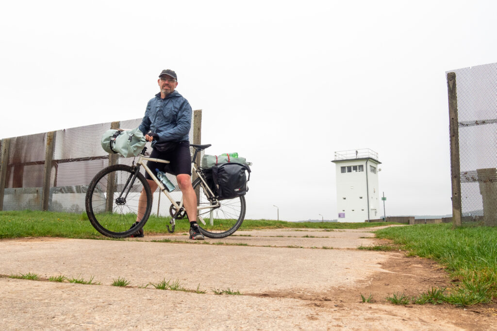 Radfahrer auf der Radtour Grünes Band vor einem alten Grenzturm
